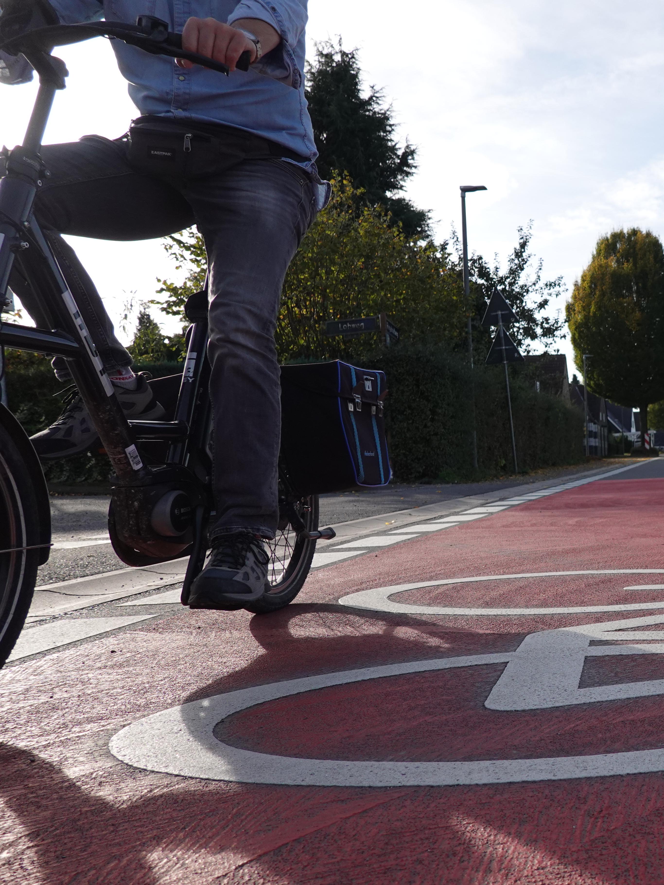Nahaufnahme Fahrradmarkierung auf Weg mit Fahrradfahrern.