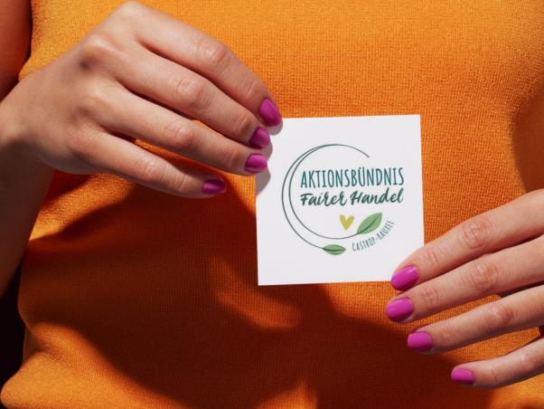 Frau h&auml;lt K&auml;rtchen vom Aktionsb&uuml;ndnis Fairer Handel