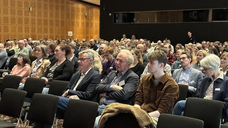 Teilnehmende im sitzen vor B&uuml;hne und verfolgen den Archivtag.
