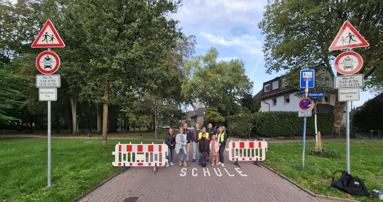 Gruppenbild an Stra&szlig;enschildern mit Absperrbake