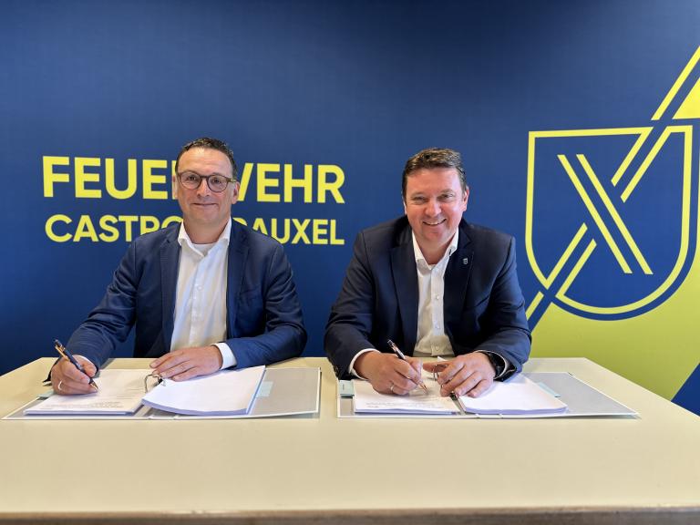 Zwei M&auml;nner unterzeichnen Vertr&auml;ge